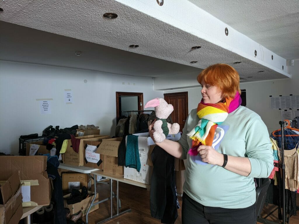 Hannele Känd holding a toy Piglet in the donation sorting centre